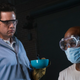 Father Gabriel (Seth Gilliam, right) may be ill and forced to make weapons designed to kill his friends, but at least his mask protects him from the smell of Eugene’s (Josh McDermitt) dinner.